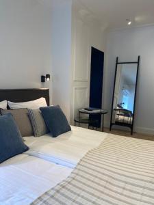 a bedroom with a large bed and a mirror at Hotel Villa Verdi in Knokke-Heist