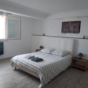 a white bedroom with a bed and a window at Au petit bois magique in Payrac +23 photos