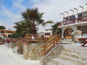 a resort with a palm tree and a building at Hotel & Cabañas El Mirador Caldera in Caldera