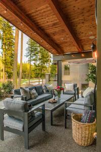 a patio with couches and a table and chairs at 5 King Beds! Golf Course View on Huge Shaded Deck in Cle Elum