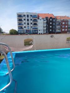 a swimming pool with a building in the background at Stan na dan PREMIUM 2 apartman in Obrenovac