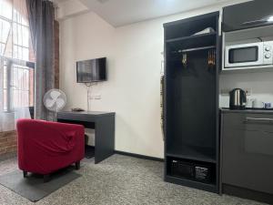 a room with a red chair and a kitchen at Kick back relax stylish space in Nottingham