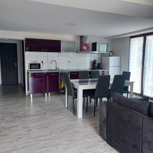 a kitchen and dining room with a table and chairs at Au petit bois magique in Payrac