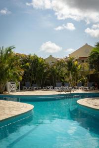 a pool at the resort with chairs and trees at Villa 5 Green Courtyard Village in Kralendijk