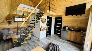 a living room with a staircase in a tiny house at Cozy A-Frame Cabin with Private Hot Tub - Chiang Mai in Şelari