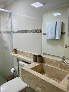 a bathroom with a sink and a toilet and a mirror at Nosso Apê - Campinas in Valinhos