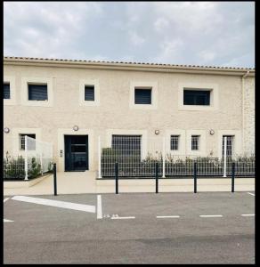 a white building with a fence in front of it at Appartement moderne proche de tout et parking gratuit in Lattes