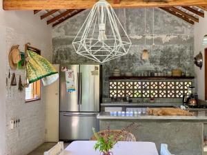 a kitchen with a stainless steel refrigerator and a chandelier at Villa Poesía in Puerto Escondido