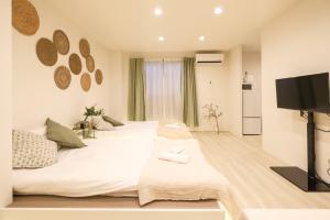 une chambre avec deux lits et une télévision à écran plat dans l'établissement Six7 APT三ノ輪, à Tokyo