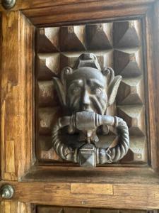 a wooden door with a statue of a lion holding a lock at Palazzo Bracciolini Nel cuore della città in Pistoia +42 photos