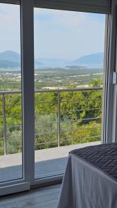 a bedroom with a large window with a view of the countryside at Sisters residence in Kotor