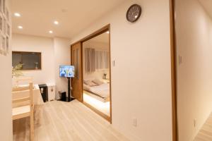 - un miroir dans une chambre avec un lit et un lavabo dans l'établissement Six7 APT三ノ輪, à Tokyo