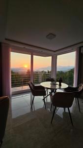 a room with a table and chairs and a large window at Sisters residence in Kotor