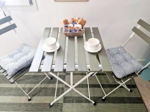a table with a basket of food and two chairs at Les logements de Laura in Saint-Maur