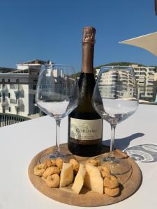 a bottle of wine and two glasses on a table at Luris apartament Himare in Himare