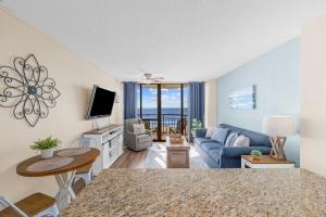 a living room with a blue couch and a tv at Stunning 1 Bedroom Condo-Breathtaking Oceanfront Views-Meridian 602 in Myrtle Beach