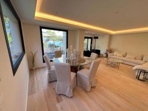 een woonkamer met een tafel en witte stoelen bij Villa Eden Cap Martin in Roquebrune-Cap-Martin