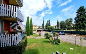 a house with a white fence next to a parking lot at Cappuccini Appartments in Peschiera del Garda