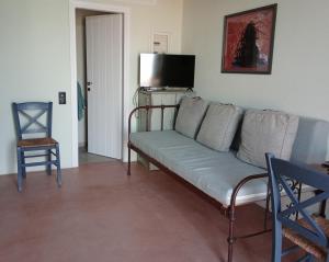 a living room with a couch and a television at Elva House in Panormos