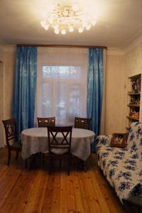 a dining room with a table and chairs and a window at Апартаменты Бутусовские in Yaroslavl