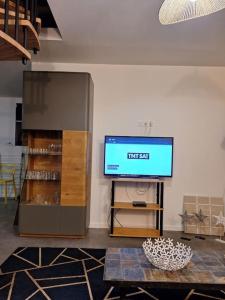 a living room with a television and a table at maison de caractère la petite madeleine in Saint-Laurent