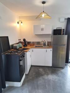 a kitchen with a black stove and white cabinets at maison de caractère la petite madeleine in Saint-Laurent +20 photos