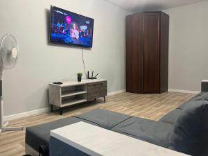 a living room with a couch and a flat screen tv at 1-ная Квартира Орбита in Rakhat
