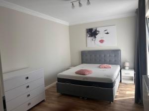 a small bedroom with a bed and a dresser at Divany Apartaments Brasov - Coresi Mall in Braşov