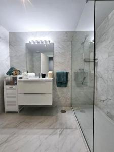 een badkamer met douche, wastafel en spiegel bij Appartement Mijas in Mijas Costa