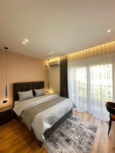 a bedroom with a bed and a large window at Ideal Apartment Shkoder in Shkodër +14 photos