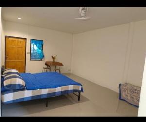 a bedroom with a bed and a table in it at Sunny in town hostel in Pai