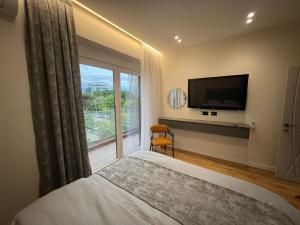 a bedroom with a bed and a large window at Ideal Apartment Shkoder in Shkodër