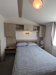 a bedroom with a large bed in a room at LOVELY BRIGHT AND AIRY CARAVAN ON THE 5 Star SHOREFIELD COUNTRY PARK ENTERTAINMENT PASSES INCLUDED in Milford on Sea