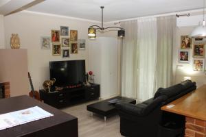 a living room with a black couch and a television at Casa do Artista in Vila Verde
