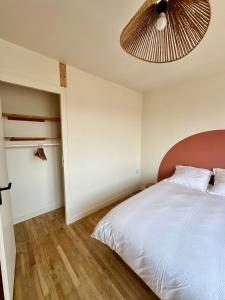 a bedroom with a white bed and a fan at Charmante Maison avec Terrasse in Angers