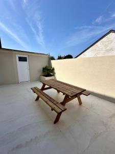 a wooden picnic bench sitting on a patio at Charmante Maison avec Terrasse in Angers