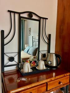 a mirror on top of a wooden dresser at Two Flowers Hotel in Pedoulas