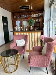 a living room with two chairs and a table at Two Flowers Hotel in Pedoulas