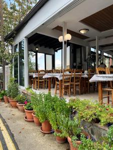 a restaurant with tables and chairs and potted plants at Two Flowers Hotel in Pedoulas