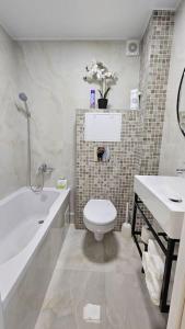 a bathroom with a toilet and a tub and a sink at Квартира в Бендерах VIP in Bender