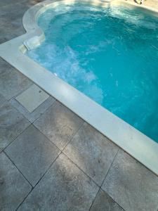 a swimming pool with a concrete curb around it at La maisonnette de Chantecoucou in Le Cannet-des-Maures +9 photos