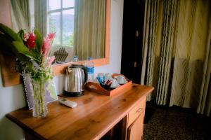 a wooden desk with a vase of flowers on it at Evergreen Villa - Sinharaja in Deniyaya