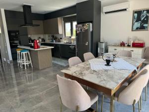 a kitchen with a table and chairs in a kitchen at Misafirlerin favorisi Villa naz in Dosemealti
