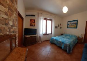 a bedroom with a bed and a television in it at B&B Marino E Lily in Baratili San Pietro