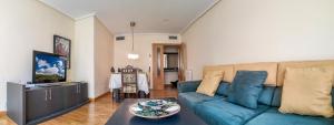a living room with a blue couch and a table at Logroño: Piso con Garaje y Piscina. in Logroño