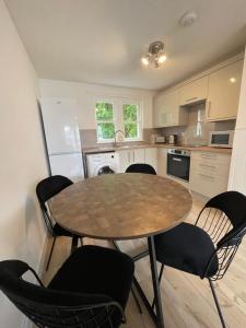 a kitchen with a table and chairs in a kitchen at The Ship Inn's Cabin in Gatehouse of Fleet