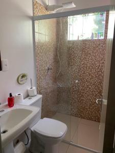 a bathroom with a shower and a toilet and a sink at Recanto da Cancela in Penha +7 photos