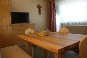a dining room with a wooden table and a television at Berghaus-Olymp Kronplatz in Brunico