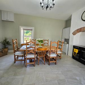 a kitchen with a dining room table and chairs at Quilly Farm House - North Coast - Entire House, near Castlerock, Coleraine, Beach walks, countrywalks, golf courses in Articlave