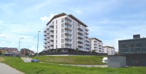 a large white apartment building on a grassy field at Apartament M&A in Łomża